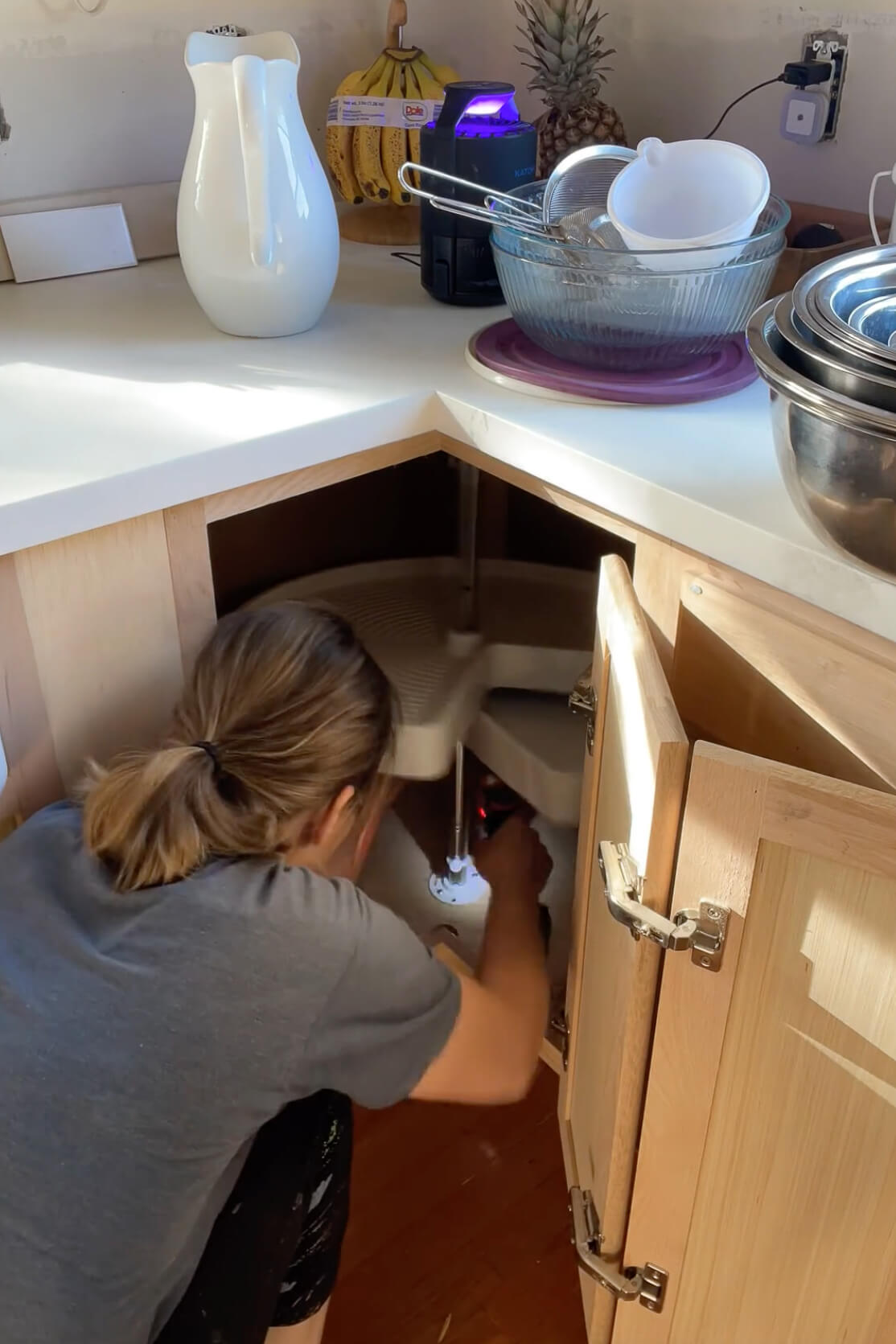 Removing a Lazy Susan from a kitchen cabinet.